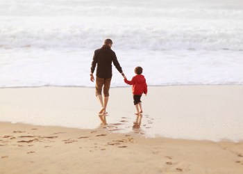 A 5 years old boy and his dad on the beach