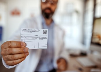 Doctor showing vaccine card at vaccination site