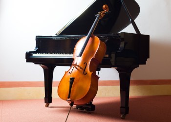 violin leaning on a piano