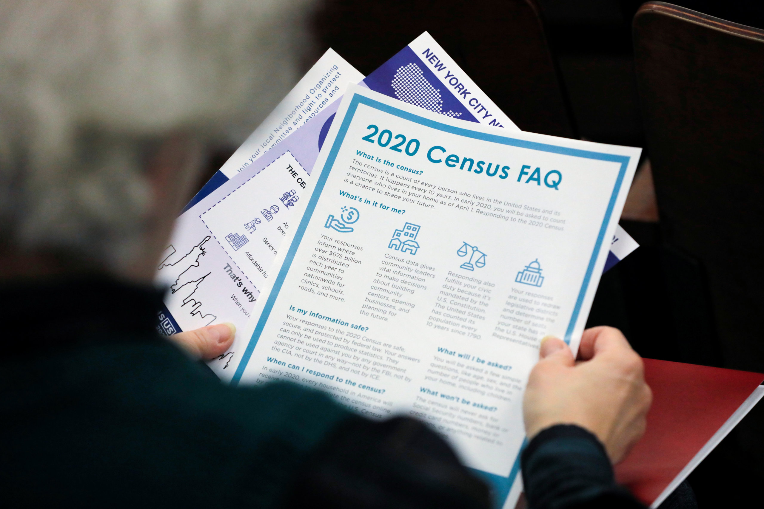 A person holds census information at an event where U.S. Rep. Alexandria Ocasio-Cortez (D-NY) spoke at a Census Town Hall at the Louis Armstrong Middle School in Queens, New York City, U.S., February 22, 2020.