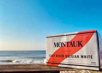 Case of Montauk Brewing Co. Easy Riser Belgian White beer by the ocean