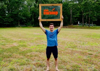 Hamptons Pride President Tom House displaying a sign for The Swamp