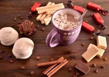 coffee mood, coffee beside chocolate waffles coffee grains and cinnamon sticks, coziness, selective focus.