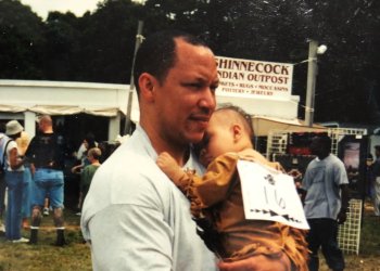 A young Asia Cofield held by her father, Jason Hansana-Cofield, at the 2001 Shinnecock Powwow