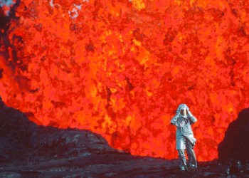 Katia Krafft wearing aluminized suit standing near lava burst at Krafla Volcano, Iceland, from 