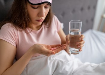 Young woman taking sleep aids