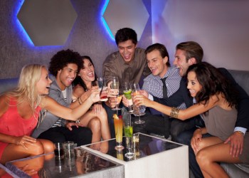 Friends toasting cocktails in nightclub