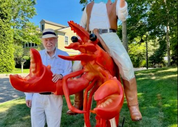 Dan Rattiner with his lobster statue outside of the new Dan's Papers office.