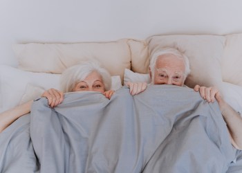 Beautiful senior couple enjoying time together at home - Romantic moments at home, elderly couple in bed needs to rekindle their sex life