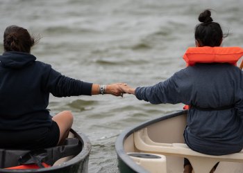 A mother and daughter hold hands at the start of the 2021 annual Shinnecock Whalers Mishoon Race