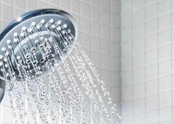 Modern Shower head with running water in white bathroom