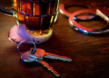 Mug of frothy beer with car keys - recipe for a DUI arrest