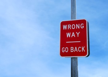 Red wrong way go back sign against a blue sky - learn lessons from your mistakes