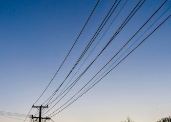 Waxing crescent moon over silhouette powerlines at dawn. Auckland. Vertical format. (Getty Images)