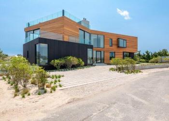 The “Bow-Tie House” in Amagansett earned its name because two “salt-and-pepper volumes intersect in a vertical relationship,” one being black, the other being a pale wood color