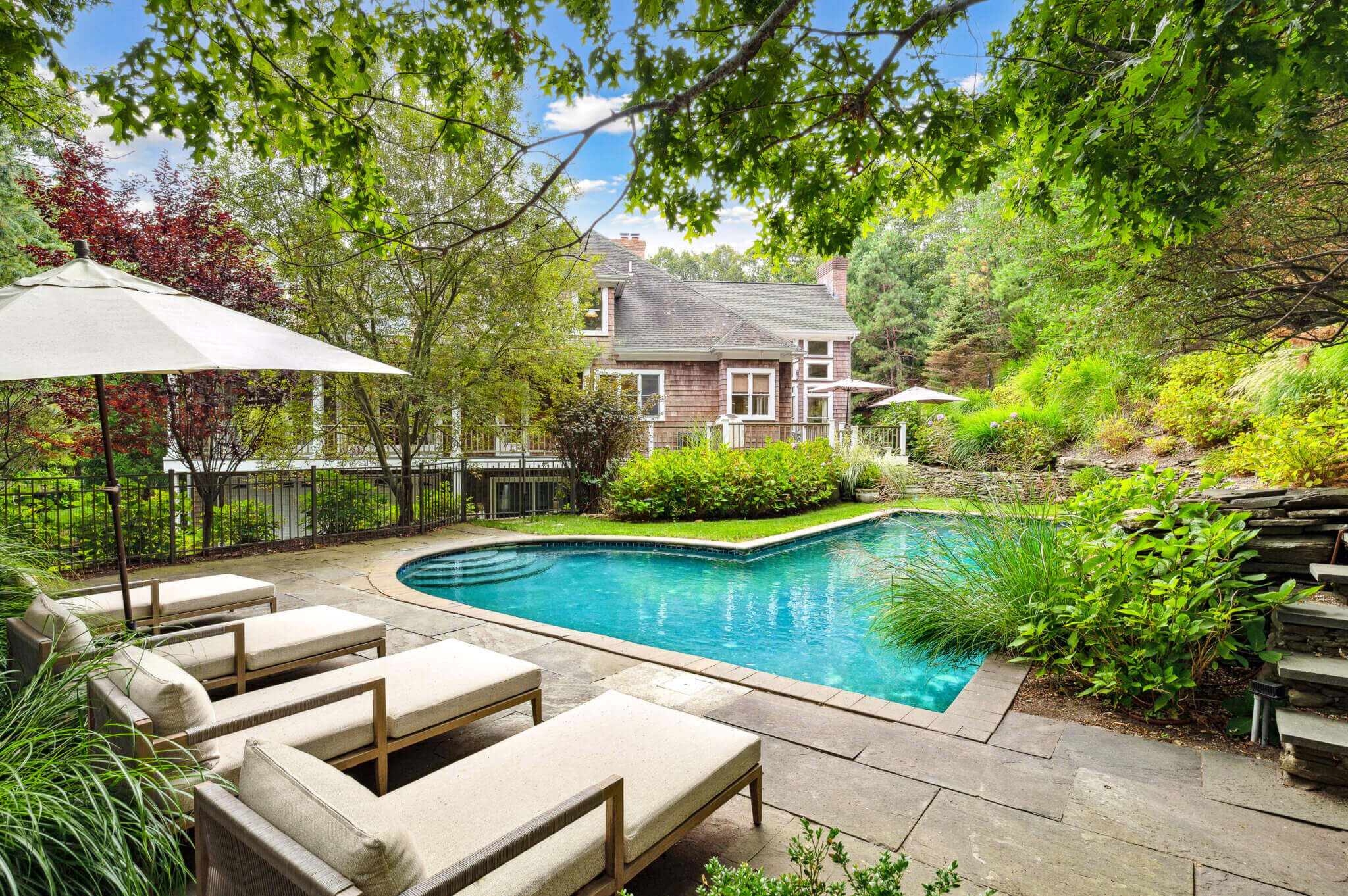 Lush landscaping surrounds the heated pool at the home at 1620 Deerfield Road in Water Mill, Courtesy of Mala Sander