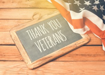 Veterans day background with chalkboard on wooden table and USA flag