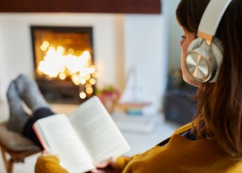 Woman with headphones reading in living room