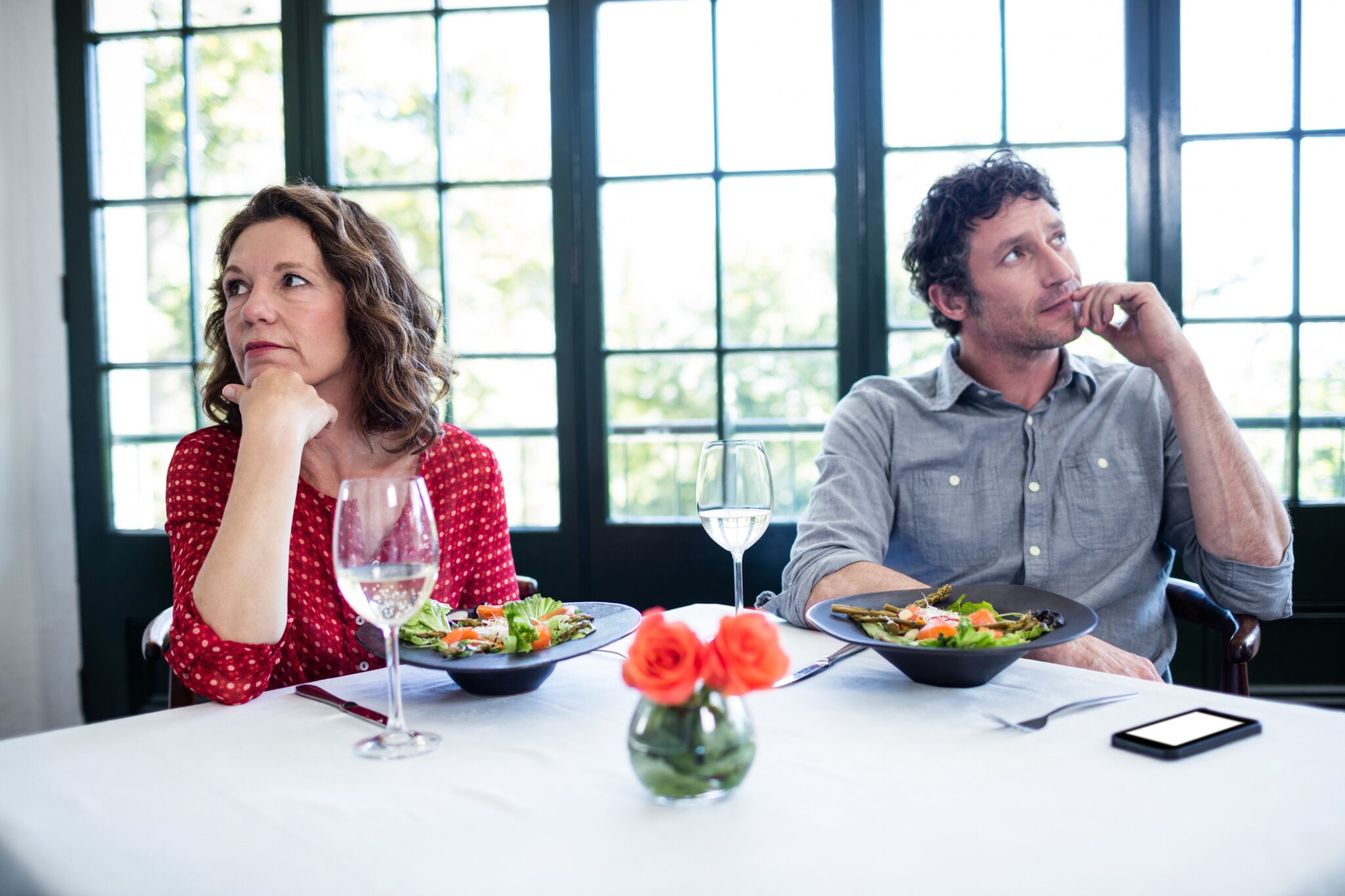 Woman feeling bored and ignoring each other in restaurant