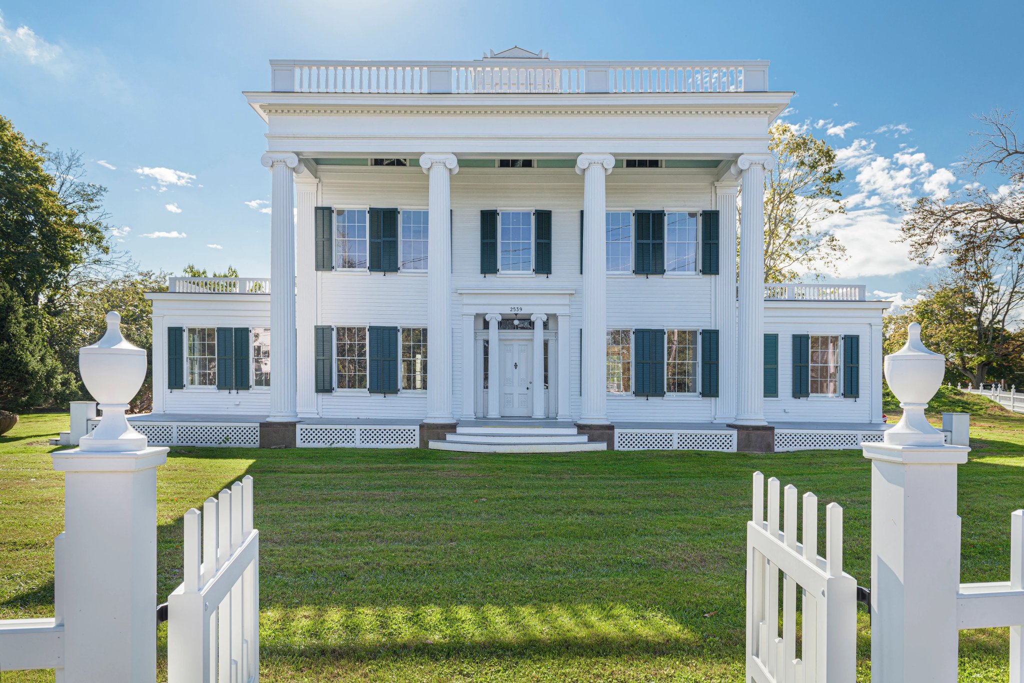 The Nathaniel Rogers House, the newly renovated and fully restored Greek-revival residence is now outfitted with replica wooden shutters and a white picket fence in Bridgehampton