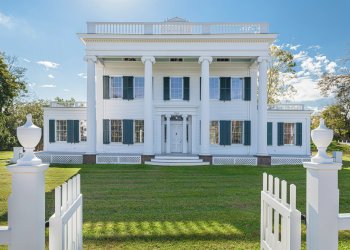 The Nathaniel Rogers House, the newly renovated and fully restored Greek-revival residence is now outfitted with replica wooden shutters and a white picket fence in Bridgehampton