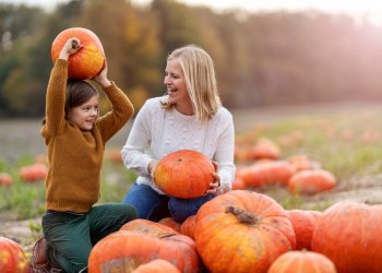 Kids with mom in fall pumpkin patch