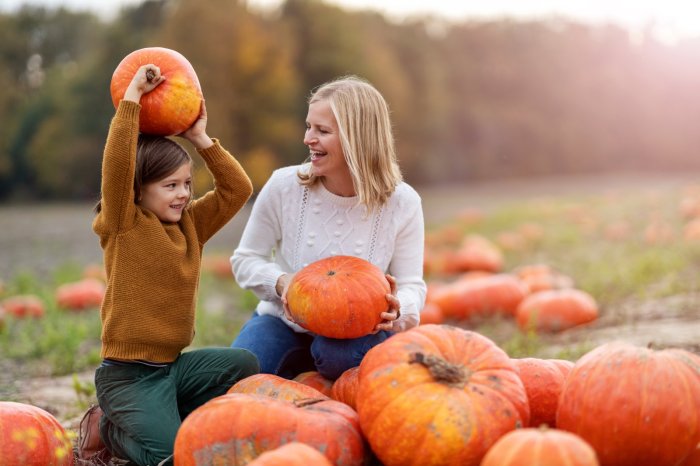 Kids with mom in fall pumpkin patch