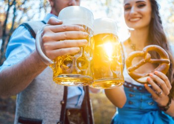 Couple Toasting Beer Glasses While Standing Outdoors