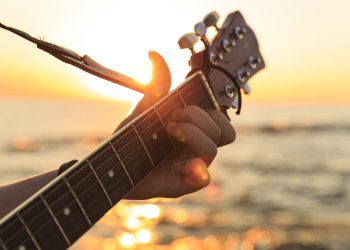 Hand on guitar strings at sunset - There will be sunset music in Sagaponack in the Hamptons on Sept. 21.