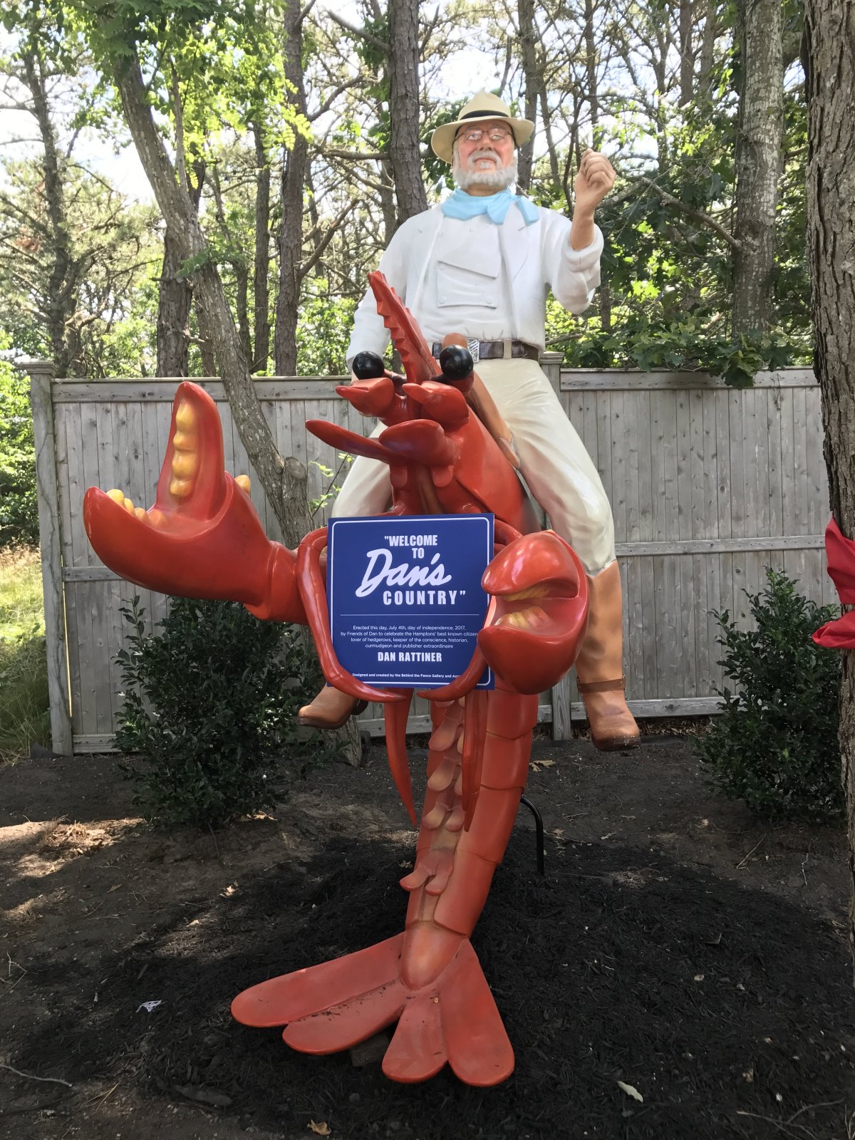 A statue of Dan's Papers founder Dan Rattiner riding a lobster, set outside the Southampton office.