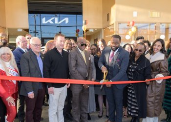 Adonai McCormack, holding the scissors, officially cuts the ribbon for Eagle Kia of Riverhead.