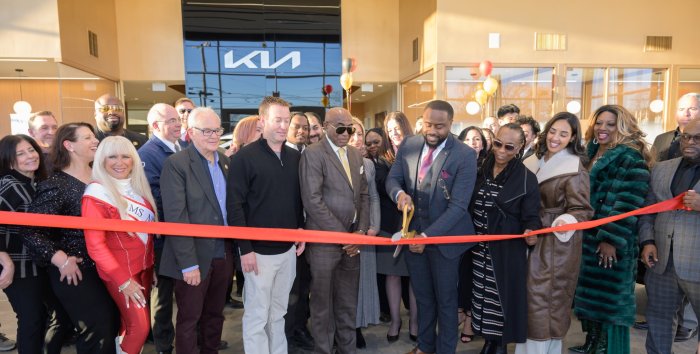 Adonai McCormack, holding the scissors, officially cuts the ribbon for Eagle Kia of Riverhead.