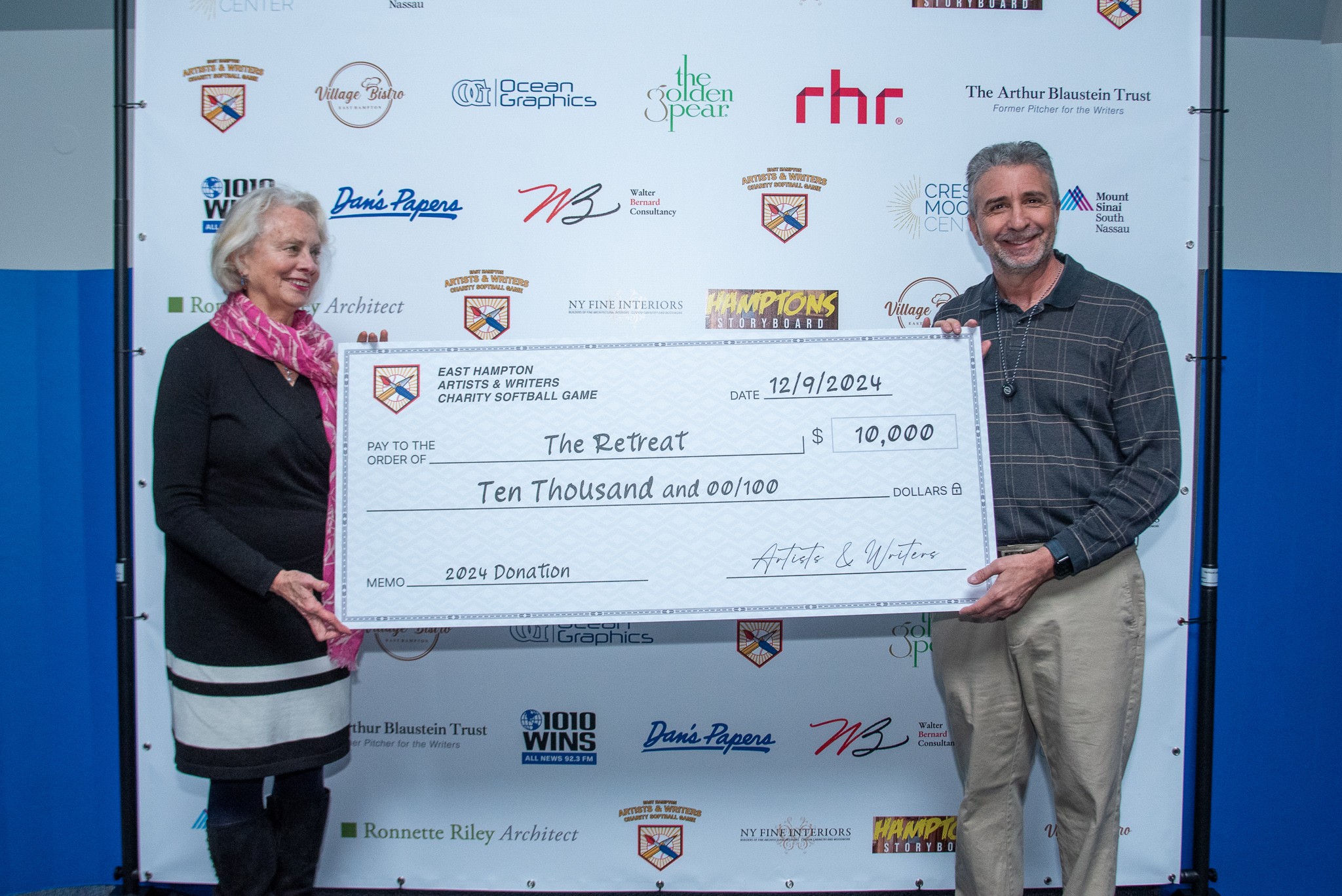 David Brandman presents check to Loretta Davis of The Retreat from this years Artists & Writers Game 2024