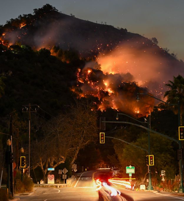 A view of flames at the mountain as seen from Topanga Canyon near Pacific Palisades in Topanga, Los Angeles, California, United States on January 9, 2025. A fast-moving wildfire has forced 180,000 people to evacuate, with officials warning that worsening winds could further escalate the blaze.