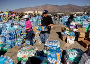 Volunteers carry water for evacuees from the Eaton fire at a donation center in Santa Anita Park, Arcadia, California. Officials warn that strong winds are pushing deadly wildfires through Los Angeles, devastating neighborhoods and displacing thousands.