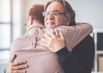 Son hugs his own father showing relational love